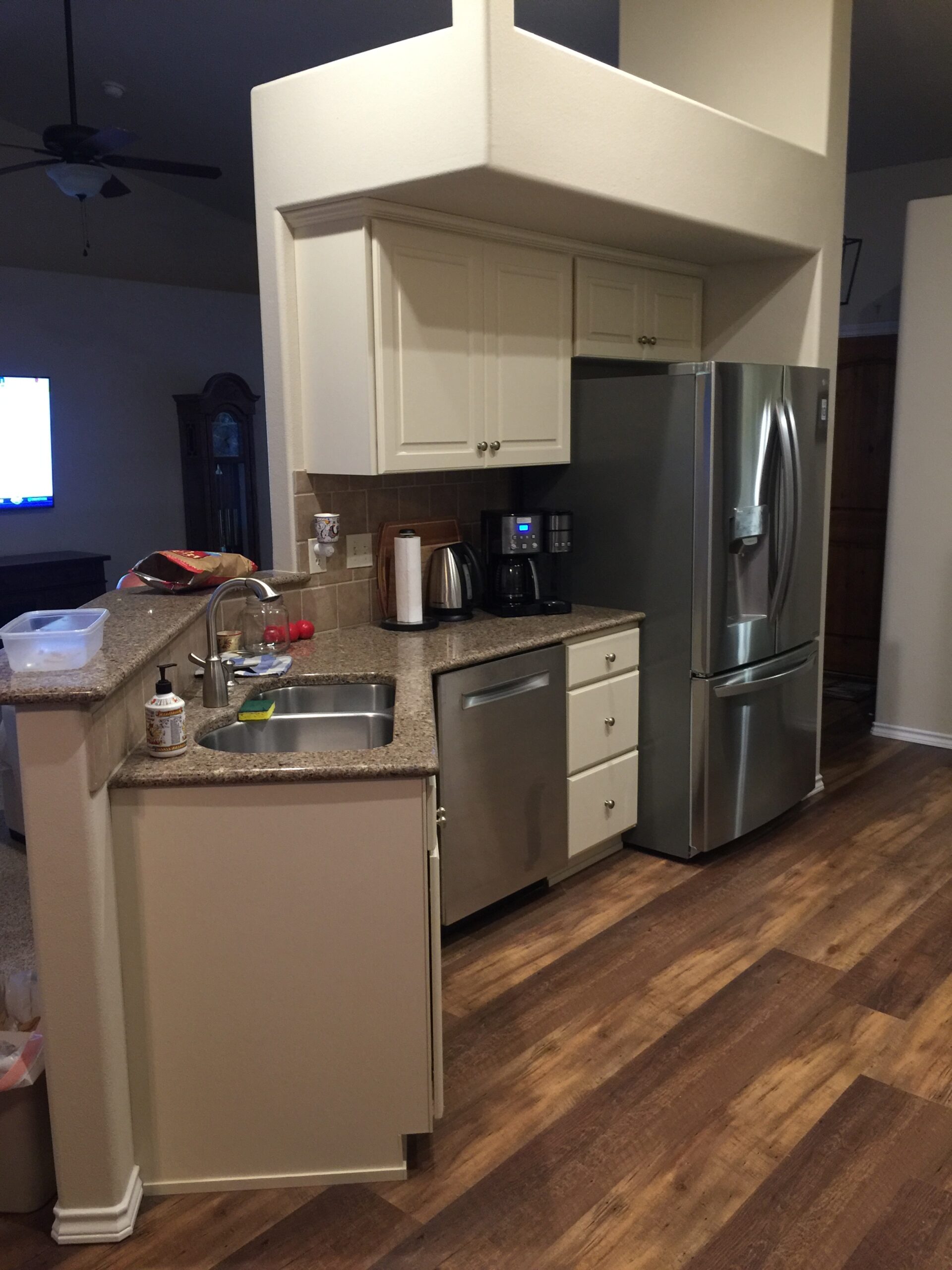 Modern Kitchen Showcasing Stainless Steel Appliances, Beige Cabinets, and a Spacious Layout With Hardwood Floors, Ideal for Cooking and Entertaining.